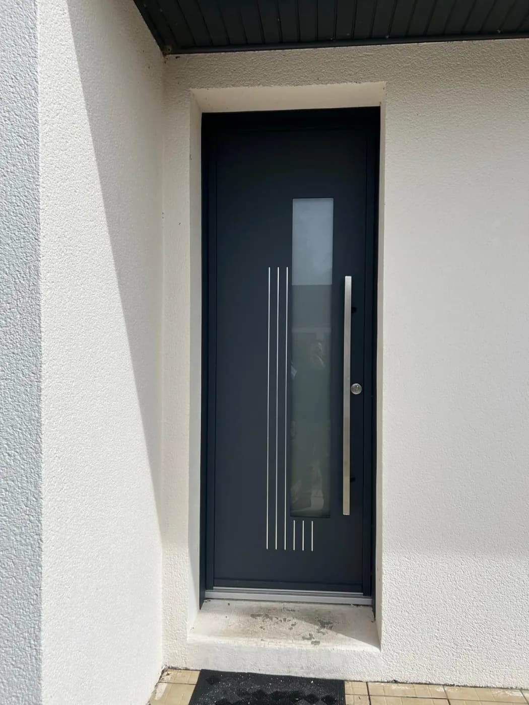 Porte d'entrée en aluminium anthracite avec poignée inox, installée près de Nantes