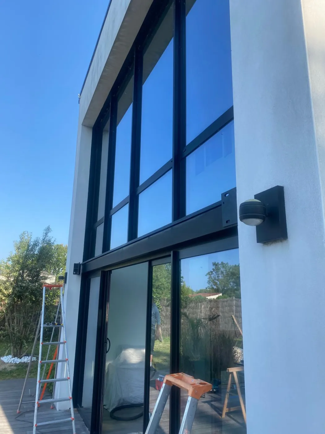 Pose d'une verrière et d'une grande baie vitrée en aluminium noir sur une maison contemporaine