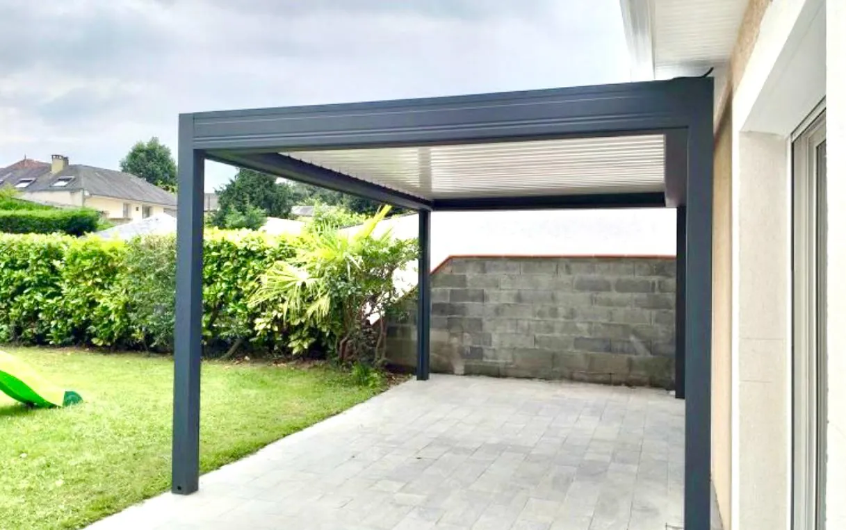 Pergola bioclimatique en aluminium anthracite ouverte sur le jardin