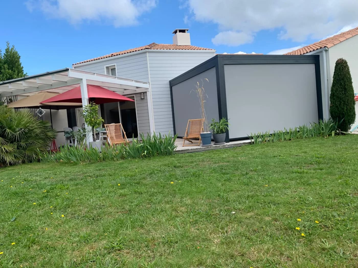 Pergola bioclimatique anthracite avec toile screen, ouverte sur le jardin